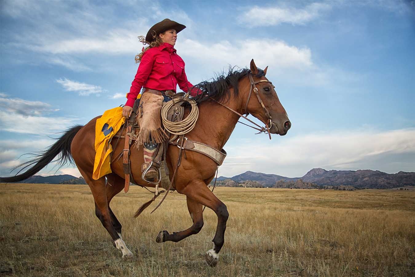 Lady riding a horse with a adult saddle slicker